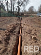 На фото показан монтаж канализационных труб в траншее от частного дома до септика, выполненный с соблюдением уклона для естественного стока.